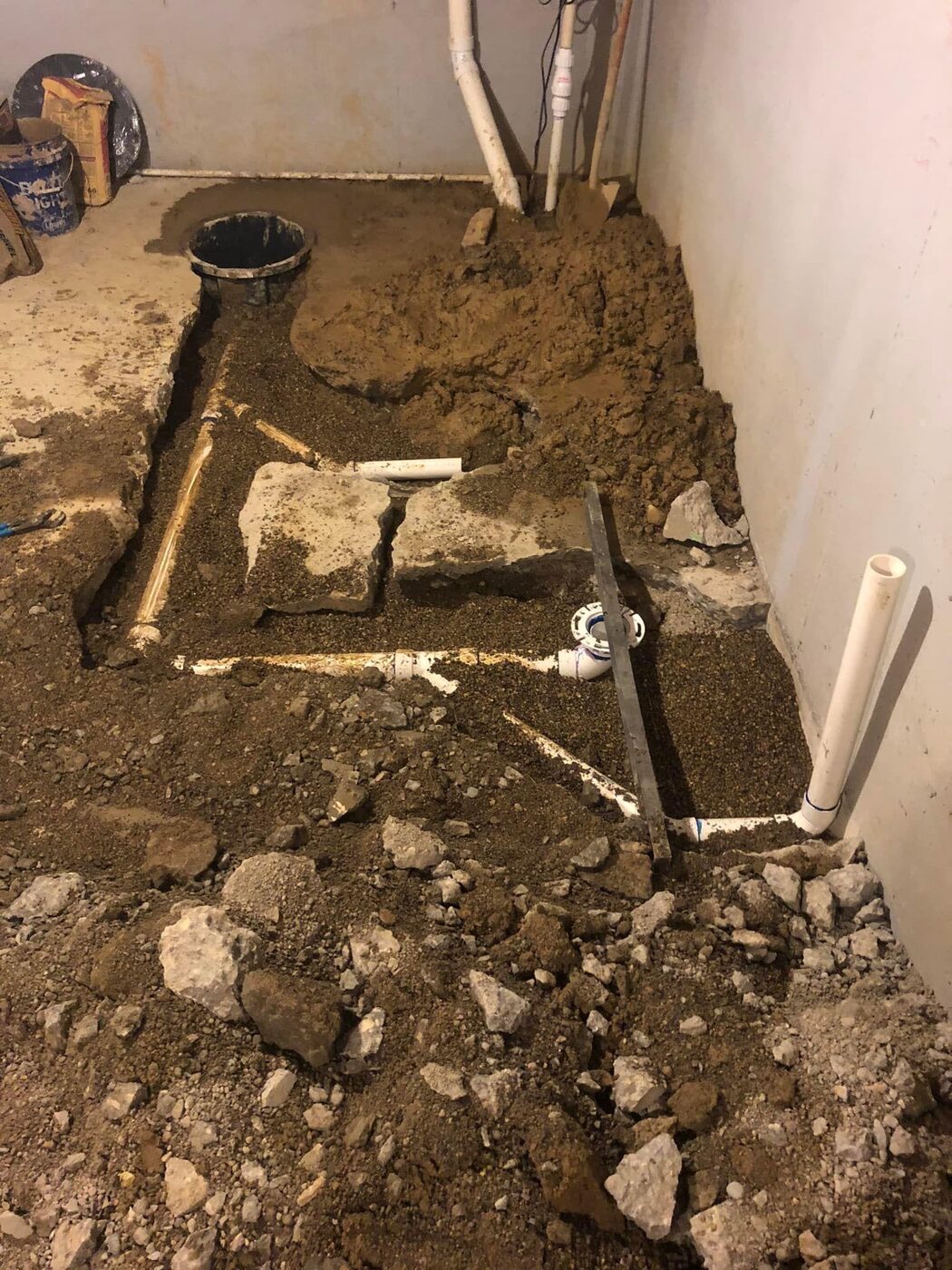 Drain line rough-in trenched into a basement floor